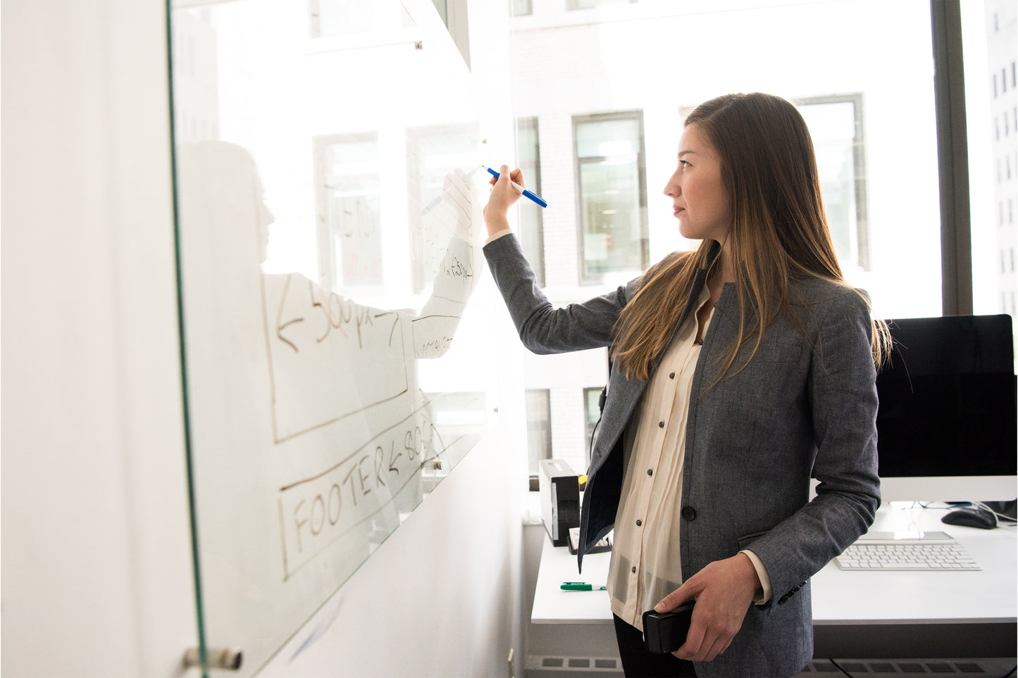A woman writing on a whiteboard in classroom